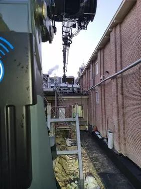 Kraanwagen moet ver reiken voor te bevoorraden op smalle strook