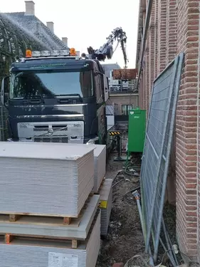 Gips voor de wagen gelost en de eigen kraan verplaatst het naar de juiste plek
