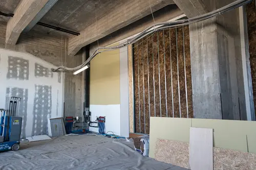 aanzicht van afgewerkt en openstaande wand met isolatie
